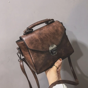 Dettaglio borsa a tracolla in pelle vintage marrone con chiusura girevole e manico