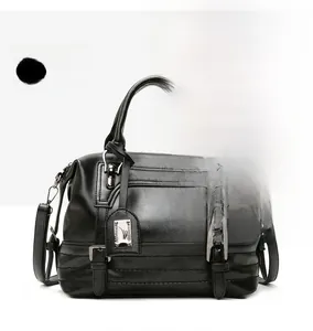 Detail of black faux leather handbag showing texture, metal shield tag and stitch pattern