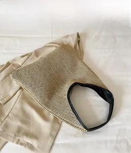 Detailed overhead view of woven straw beach tote bag with black trim and inner lining