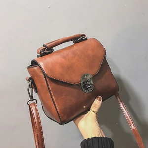 Dettaglio della borsa in pelle marrone caramello con chiusura a scatto in bronzo