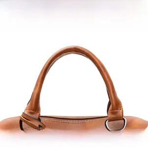 Detail of round handles and silver hardware on a vintage brown leather Boston bag