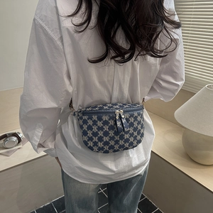 Blue jacquard belt bag with M-pattern on model in a stylish home setting