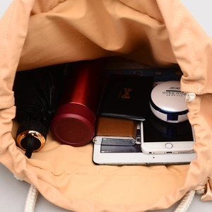 Straw weave shoulder bag with drawstring canvas liner showing large interior capacity