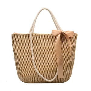 Large woven straw beach tote bag with a pink satin bow and dual rope handles