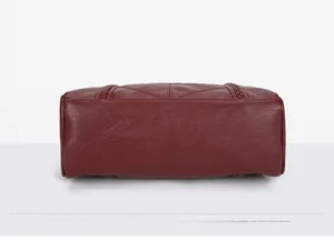 Vue détaillée du fond du sac en cuir bordeaux avec bordure tressée et coutures fines