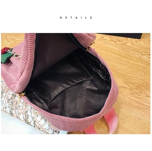 Detailed view of pink corduroy backpack interior featuring black lining and gold zipper