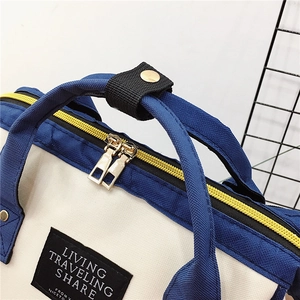 Cremefarbener Oxford-Reiserucksack mit marineblauen Griffen und Goldreißverschluss