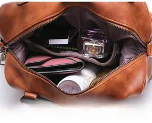 Detailed interior of a brown leather handbag showing large capacity and multi-layer pockets