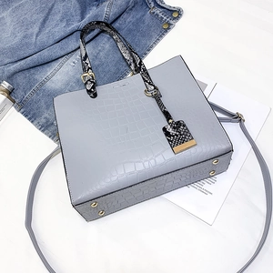 Detailed top view of light blue crocodile embossed tote bag with adjustable strap
