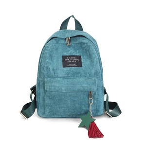 Detail of teal corduroy backpack with star charm and colorful ribbon pendant