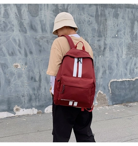 Fashionable red canvas backpack with white stripes and casual urban street style