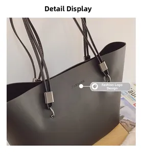 Détail du sac cabas noir montrant le logo FASHION et la bandoulière à brides multiples