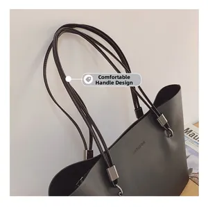 Détail des poignées confortables multi-sangles sur un sac cabas en cuir noir avec logo FASHION