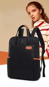 Detail of black oxford laptop backpack featuring brown leather handles and side pockets