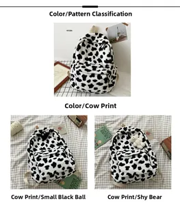 Detail view of plush cow print backpack with decorative black pompom and cute bear charm