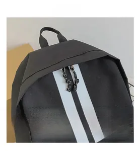 Detail show of black nylon backpack featuring dual white stripes and knotted zipper pulls