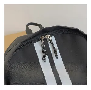 Close-up of smooth dual metal zippers with woven pull cords on a black backpack