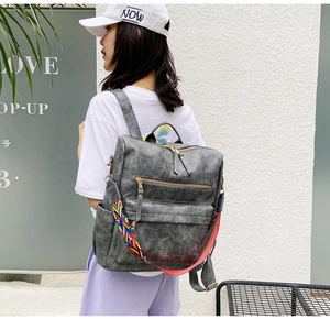 Détail du sac à dos en cuir gris rétro avec bandoulière ethnique sur un mannequin