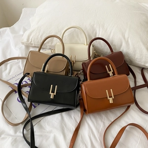 Detailed collection of vintage square handbags in five colors on a soft white bed