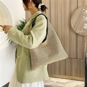 Chic large triangle straw woven tote bag with black leather handles for beach or casual wear