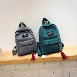 Corduroy backpacks in gray and dark green with tassel charms and star pendants