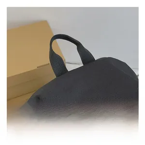 Close-up of the reinforced woven top handle on a black nylon travel backpack