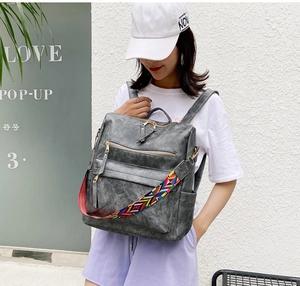 Détail du sac à dos en cuir PU gris avec une bandoulière tissée colorée de style ethnique