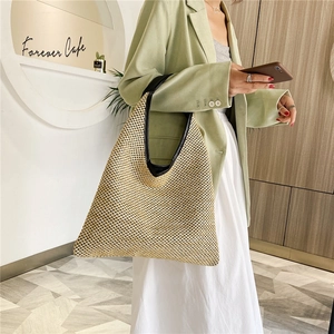 Large woven beach shoulder bag in beige straw with black leather handles and trim