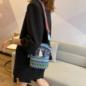 Ethnic woven bucket bag detail with colorful fringe and bohemian geometric strap