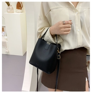 Detailansicht der schwarzen Bucket Bag mit FASHION-Prägung und verstellbarem Riemen