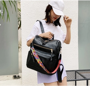 Détail d'un sac à dos en cuir noir avec bandoulière tissée colorée de style bohème