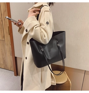 Détail d'un grand cabas en cuir noir mat avec des boucles métalliques de haute qualité