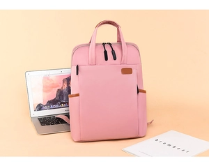 Detailed view of pink water-resistant nylon backpack with laptop compartment and front pocket