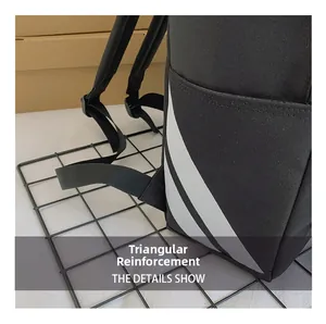 Detail of reinforced triangle stitching and side pocket on black canvas backpack