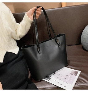Gros plan d'un sac cabas en cuir noir avec logo FASHION sur un fond de pull en maille