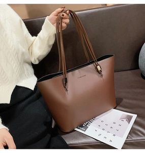Détail du grand sac cabas en cuir marron foncé avec texte FASHION et doubles anses fines en cuir