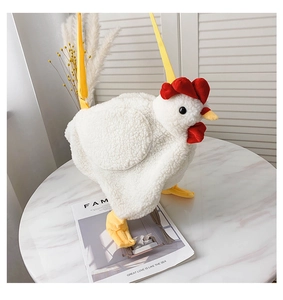 Close-up of white plush chick crossbody bag with red comb on a marble table