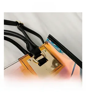 Close-up of holographic transparent bag with gold hardware and black leather strap