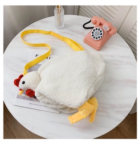 Close-up of fluffy white plush chicken bag with yellow beak and red comb on marble table