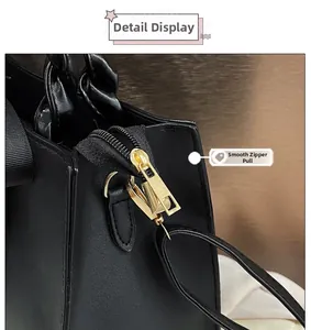Détail de la fermeture éclair dorée lisse et de la poignée tressée sur le sac noir