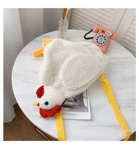 Close-up of plush chicken bag with soft wool texture on a white marble table