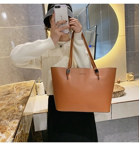 Détail du sac cabas en similicuir marron caramel avec texte FASHION en selfie
