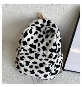 Detail of plush cow print backpack with large front pocket and soft adjustable straps