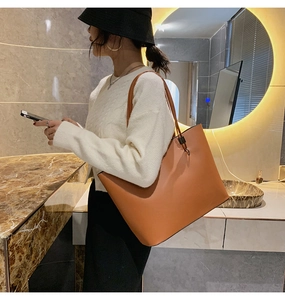 Grand sac cabas marron en similicuir avec bandoulière porté par un mannequin