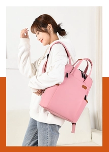 Detailed side view of pink oxford backpack featuring dual handles and side pocket storage