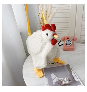Detail of cute white plush chicken bag with red crest and yellow shoulder strap