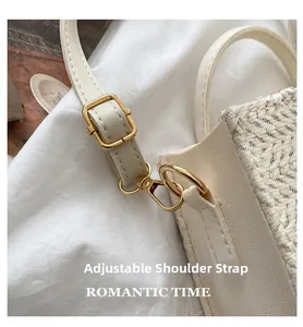 Détail de la bandoulière réglable avec boucles dorées sur le sac cabas en paille beige