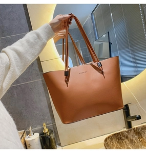 Détail du sac cabas marron en similicuir montrant le lettrage fashion et le fermoir