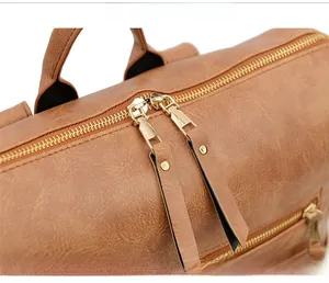 Gros plan des doubles fermetures éclair en métal sur un sac à dos vintage en cuir brun