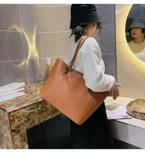 Détail d'un sac cabas en cuir caramel avec lettrage FASHION dans un cadre élégant chic